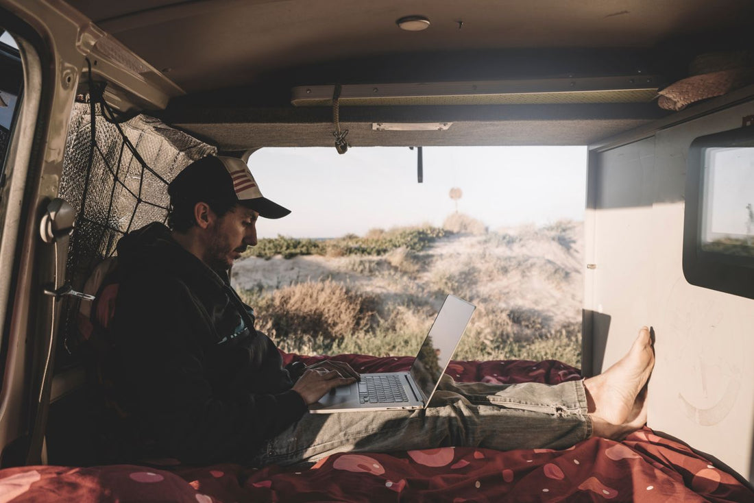 Adventurous man working with computer inside a van