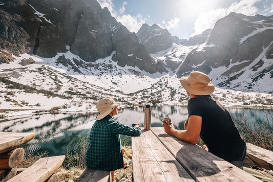 Father and son hiking traveler rest and drink tea near the mountain lake