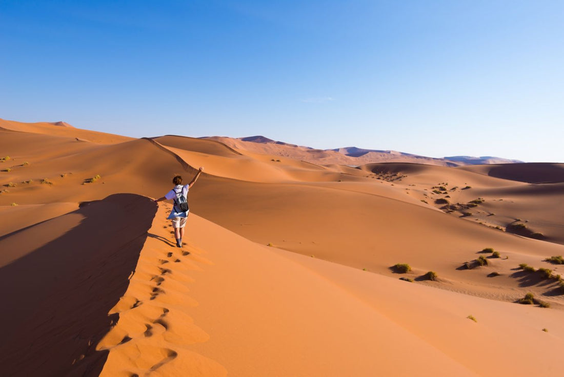 Girl walking through sand dunes