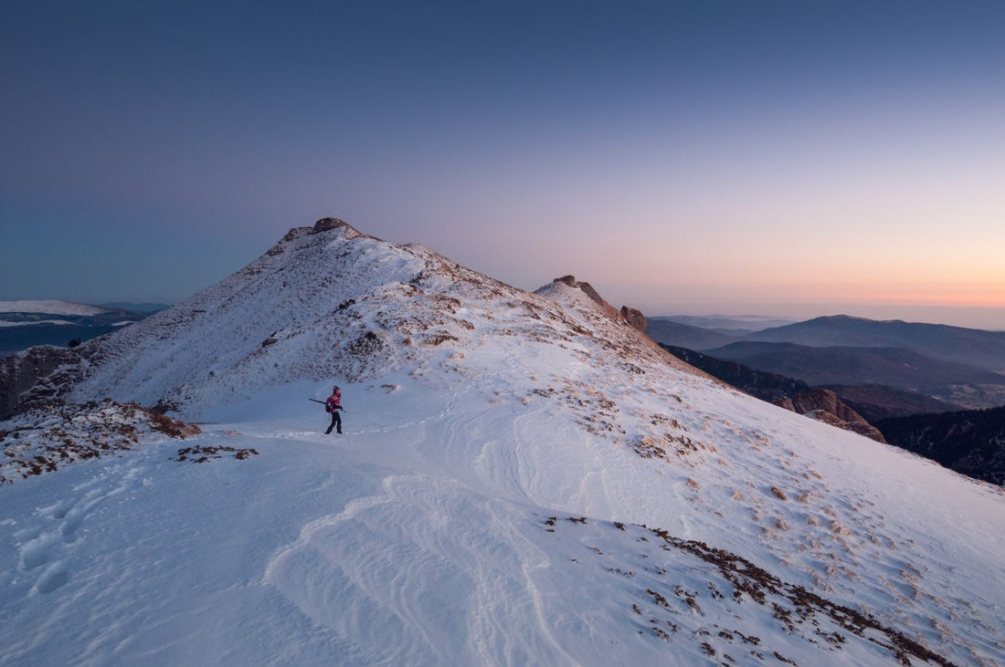 Solo traveler on snowy mountain top